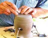 A man's hands showing spinning a pottery wheel