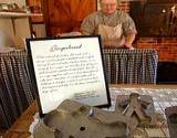 photo of a woman making gingerbread cookies at Old Bedford Village Colonial Christmas event