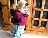 A toddler girl drinking a glass of water