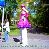 blonde woman on stilts and cowgirl outfit walking through Penn State Altoona Art Festival