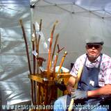 artist and canes he makes at booth at Penn State Art Festival