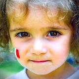 A little girl with Italian flax painted on her face at the Italian Food and Heritage Festival