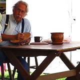 An elderly man painting his pottery at the Kutztown Fair