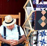 A photo of an elderly vender sleeping on a rocker at the Kutztown Fair