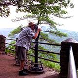 photo of man looking through a telescope to view the PA Grand Canyon