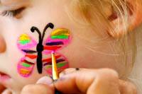 Little girl getting a butterfly painted on her face at State College Central Pennsylvania Festival of the Arts