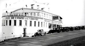 An old photo of the U.S. Grand View Hotel with antique cars parked alongside the hotel's mountain road