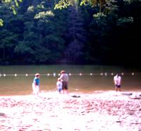 photo of myself, son and grandsons jumping in the cool lake clothes and all