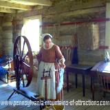 A woman operating a spinning wheel at The Old Bedford Village