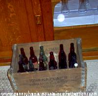 photo of a case of empty beer bottles with ghostly energy orb over it in Kelly's Bar